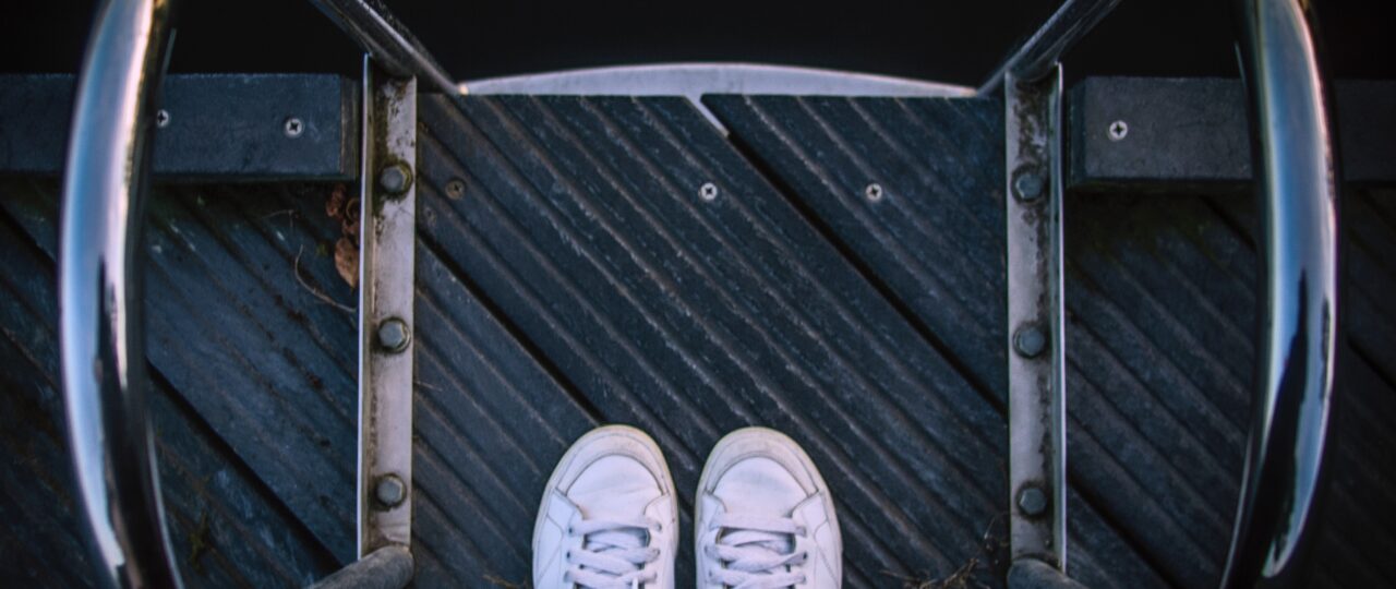 person wears pair of white low-top sneakers