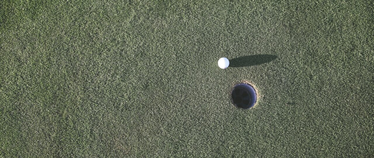 white golf ball near hole